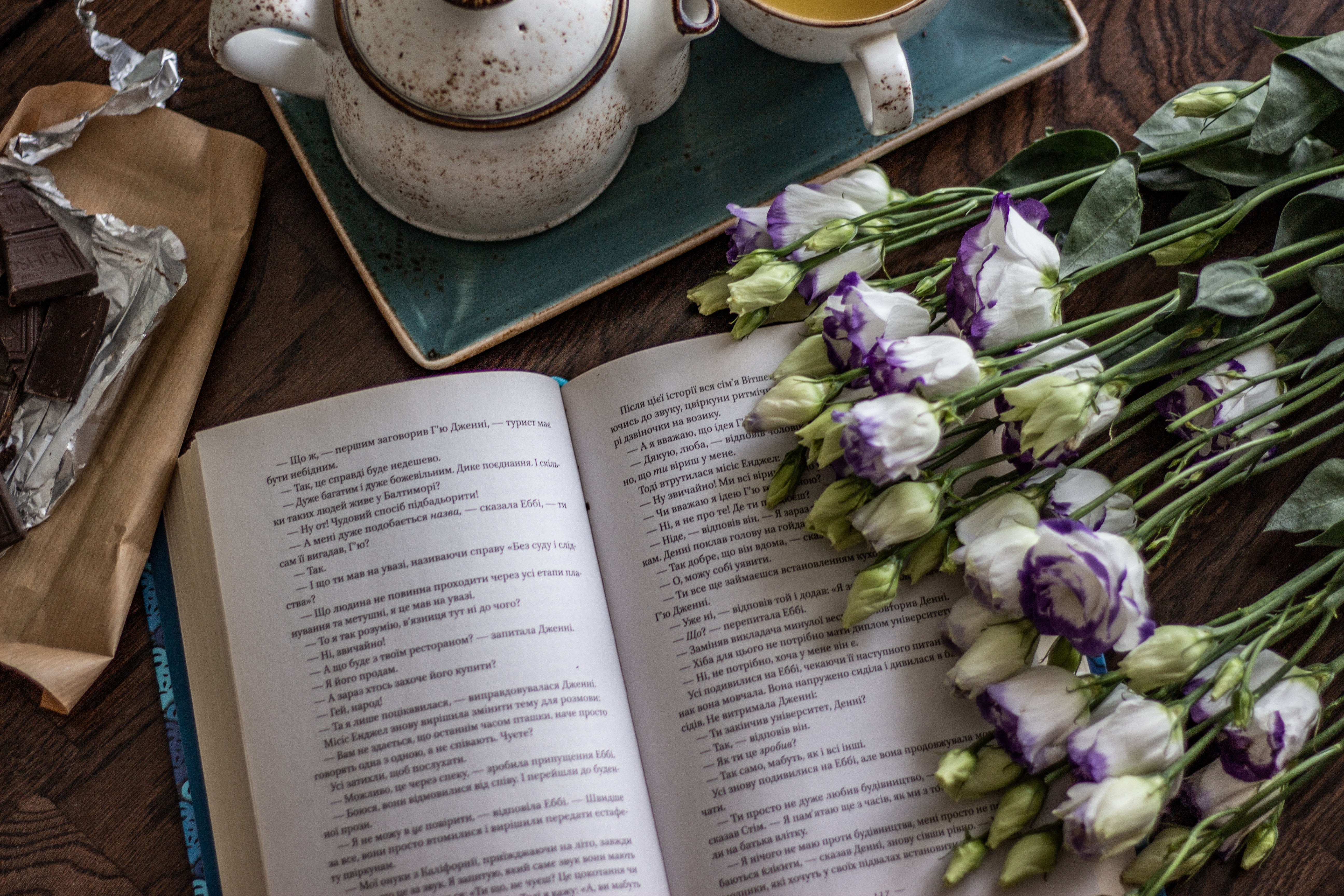 book on table with teaset and white purple-tinged roses